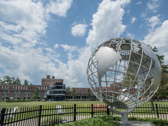 Globe sculpture with blue sky and clouds