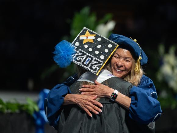 WIPSE student embracing the Westfield State University president at commencement.