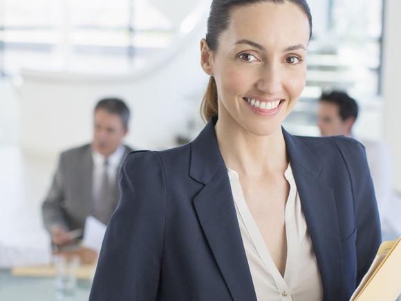 Medical Administrative Assistant smiling holding files.