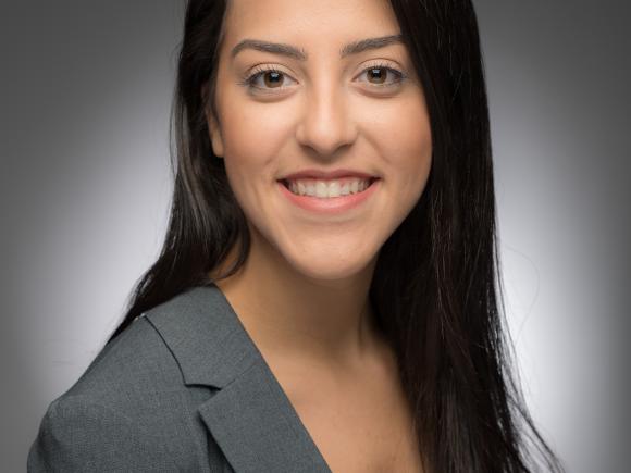 Professional headshot of Thalita Neves smiling at the camera in a gray blazer.