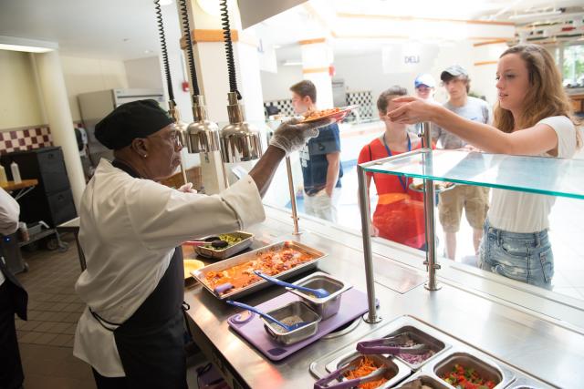 Dining commons staff serving lunch to student