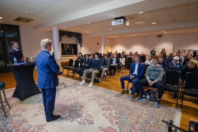 Guest speaker at finance class with a group of students listening to speaker.