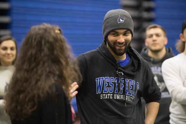 Movement science student wearing WSU sweatshirt and hat with the WSU owl logo.