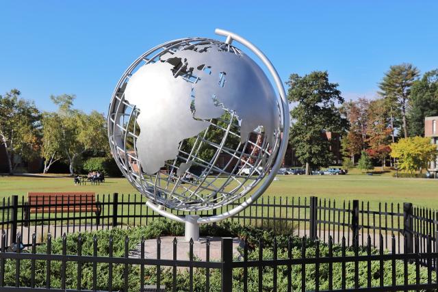 Campus globe with blue skies behind it.