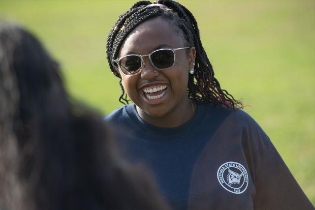 A Westfield State University psychology major laughs while talking with fellow students on the campus green.