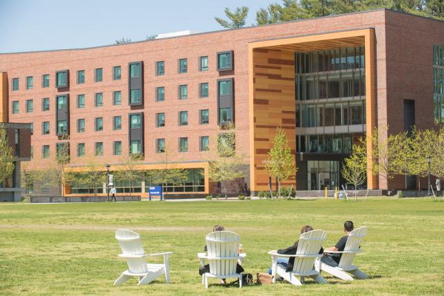 University Hall with three Adirondack chairs in front of it.