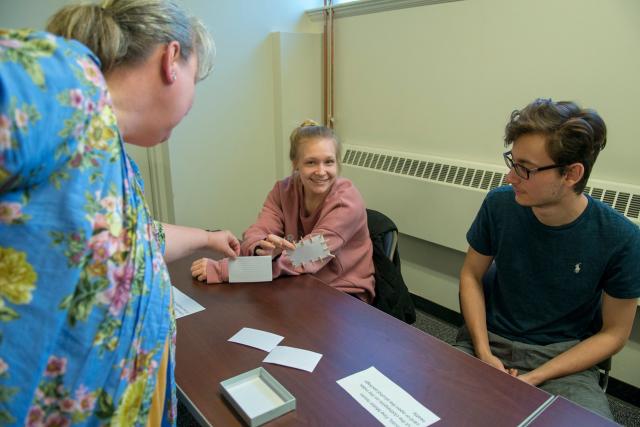 Two students working with a faculty member in a geriatric lab.