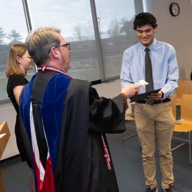 Student smiling at the Phi Alpha Theta Induction.