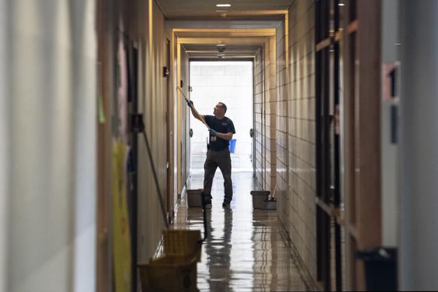 Maintainer cleaning the hallway in Scanlon Hall.