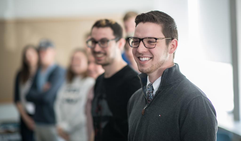 Group of students smiling as they do a class exercise in Bates Hall