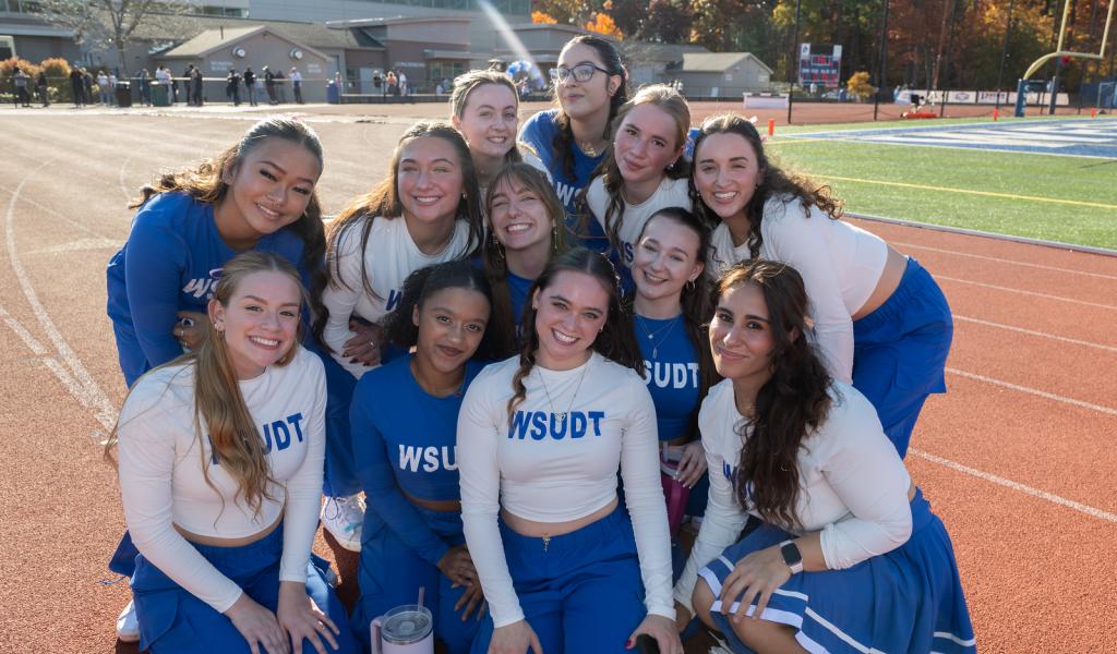 Westfield State dance team smiling during a Homecoming event on campus.