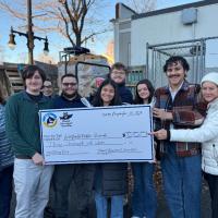 Students in the Student Government Association (SGA) holding up a big check for $3,000, which they raised for the 2024 annual turkey drive for Thanksgiving.